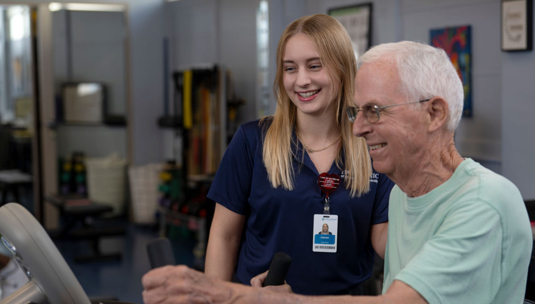 image of occupational therapy assistant student assisting geriatric patient on exercise machine
