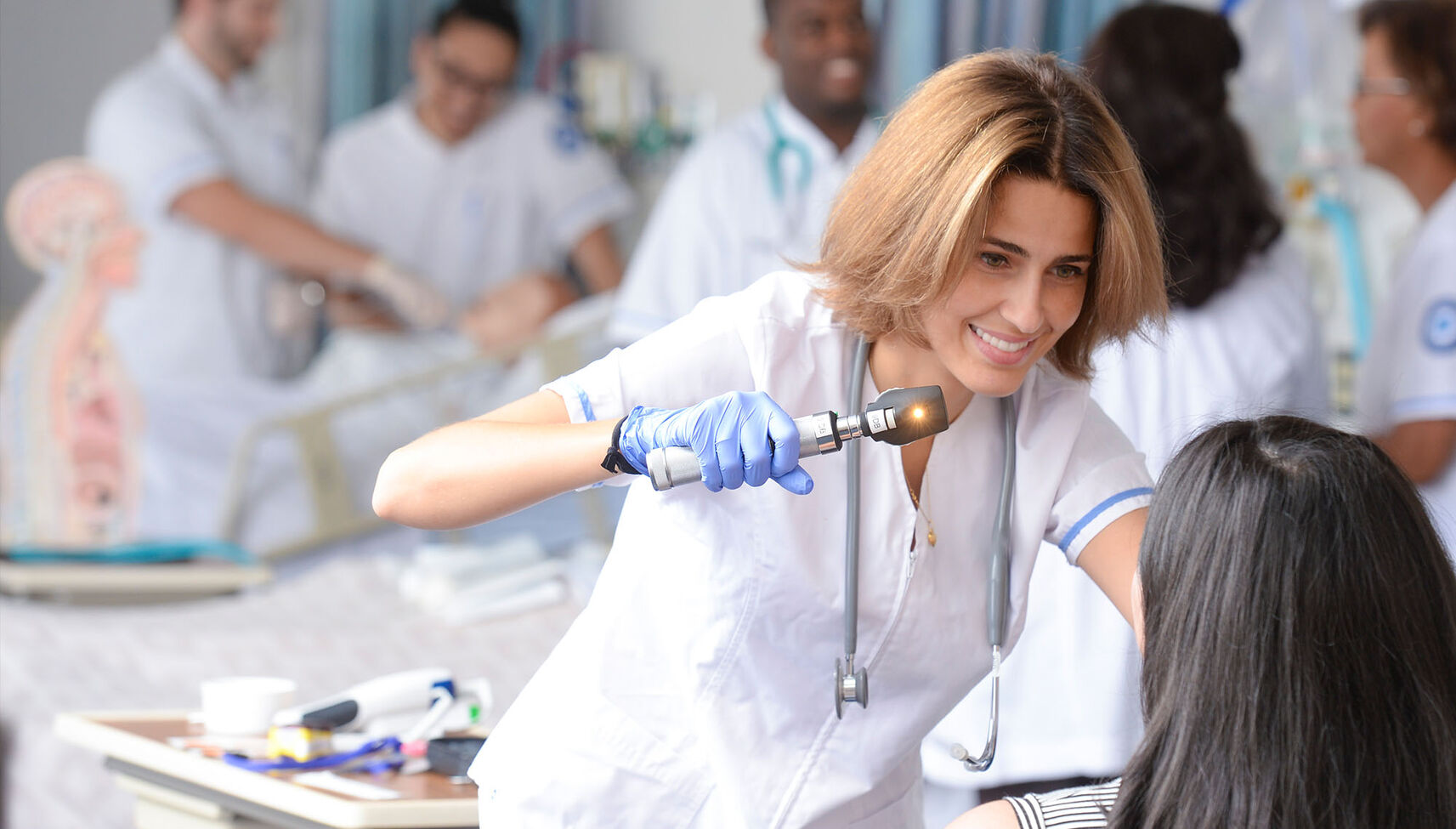 A female nursing student practices patient examinations in our skills lab
