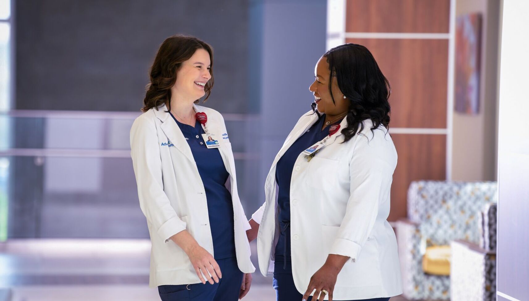 nurses in hallway smiling at each other