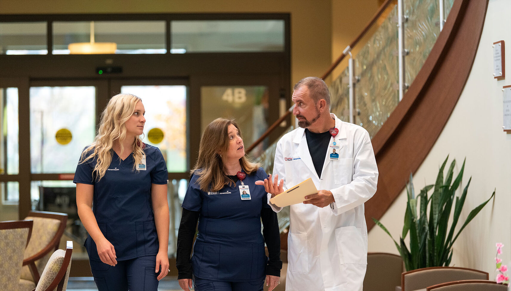 A nurse leader walks and converses with nurse team members