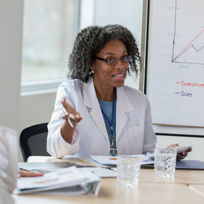 A female healthcare executive confers with her colleagues in a meeting