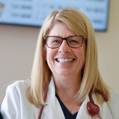A nurse practitioner smiling at a coworker