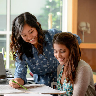 Two female students study together in a classroom